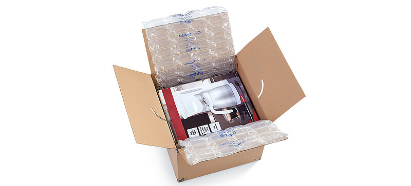 Een kartonnen doos met daarin een koffiezetter en luchtkussens