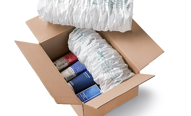 A cardboard box containing cosmetics and white paper cushioning