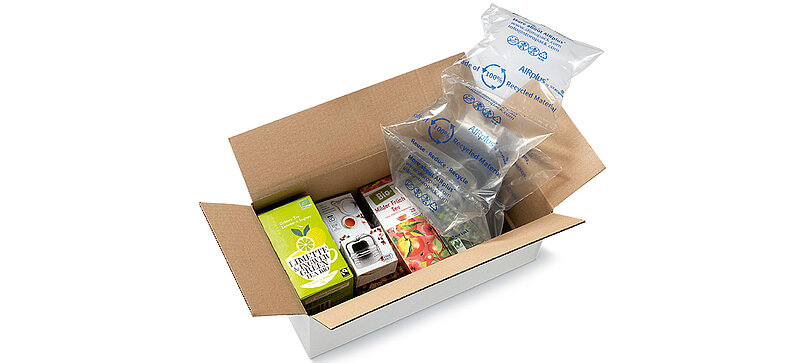 Een kartonnen doos met daarin pakjes thee en noppenfolie